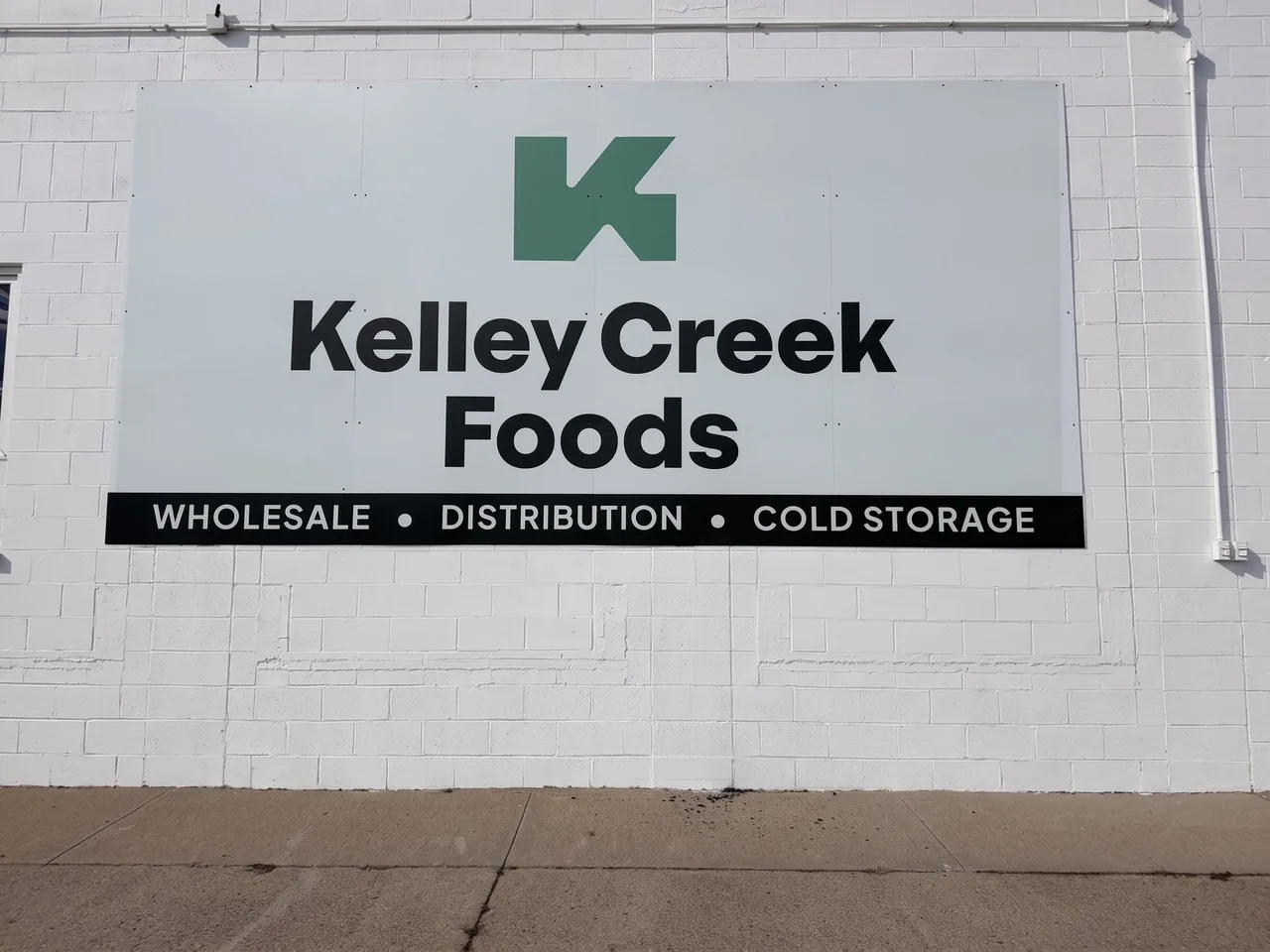 The Kelley Creek Foods sign on the front wall of the building at 2309 Myers Road, Albert Lea